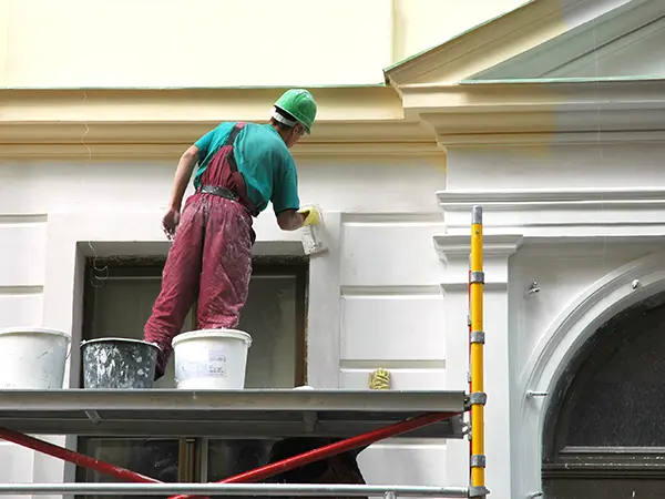 A contractor painting a house